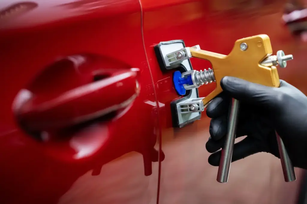 Hail-Tech technician using PDR to repair a door ding.