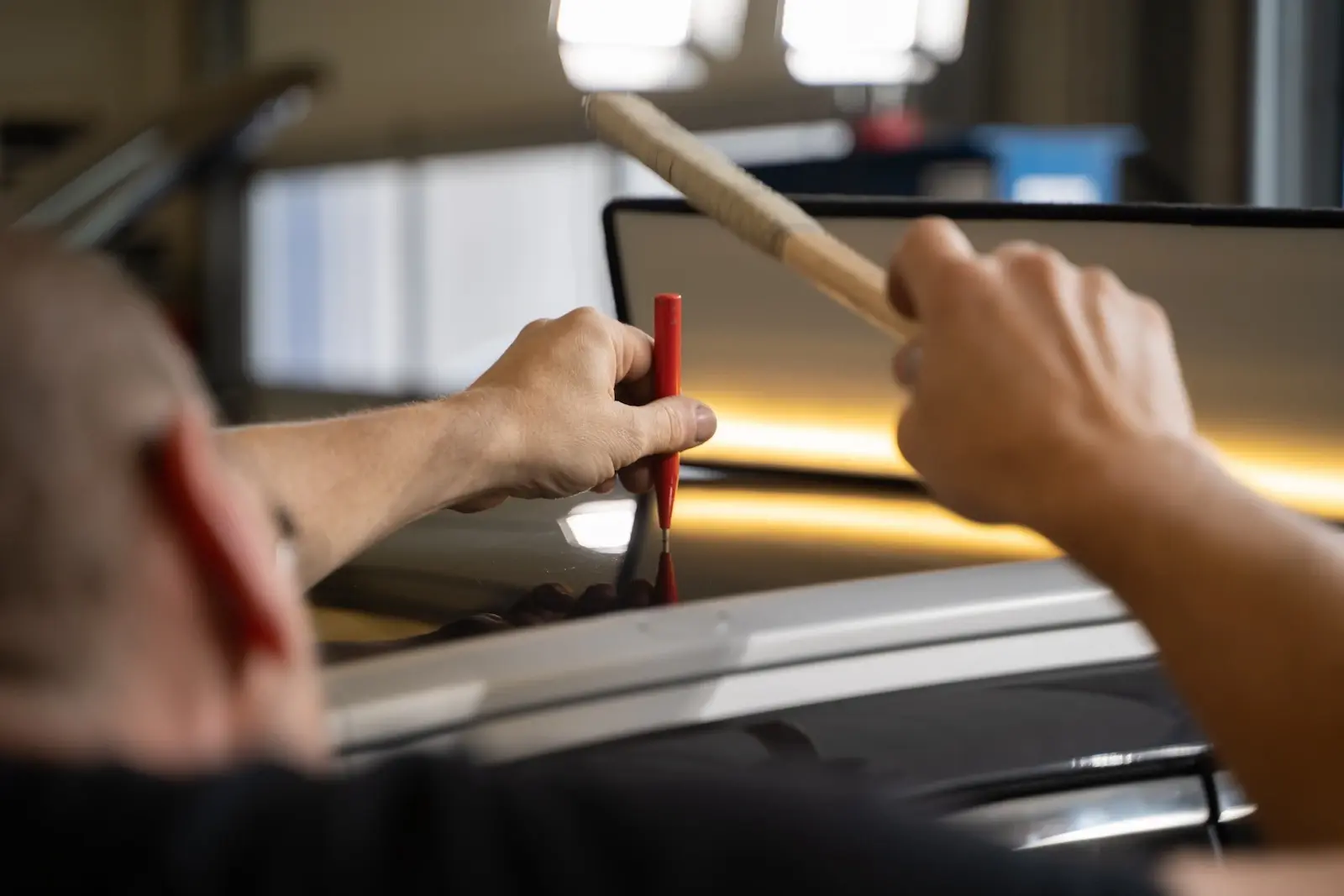 PDR technician working on a dent to restore the vehicles original condition