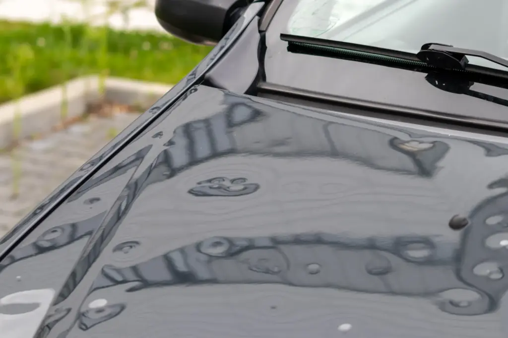 How to Choose a PDR Shop: What to Look For and What to Walk Away From 1 Multiple hail dents visible on a car's hood near the windshield