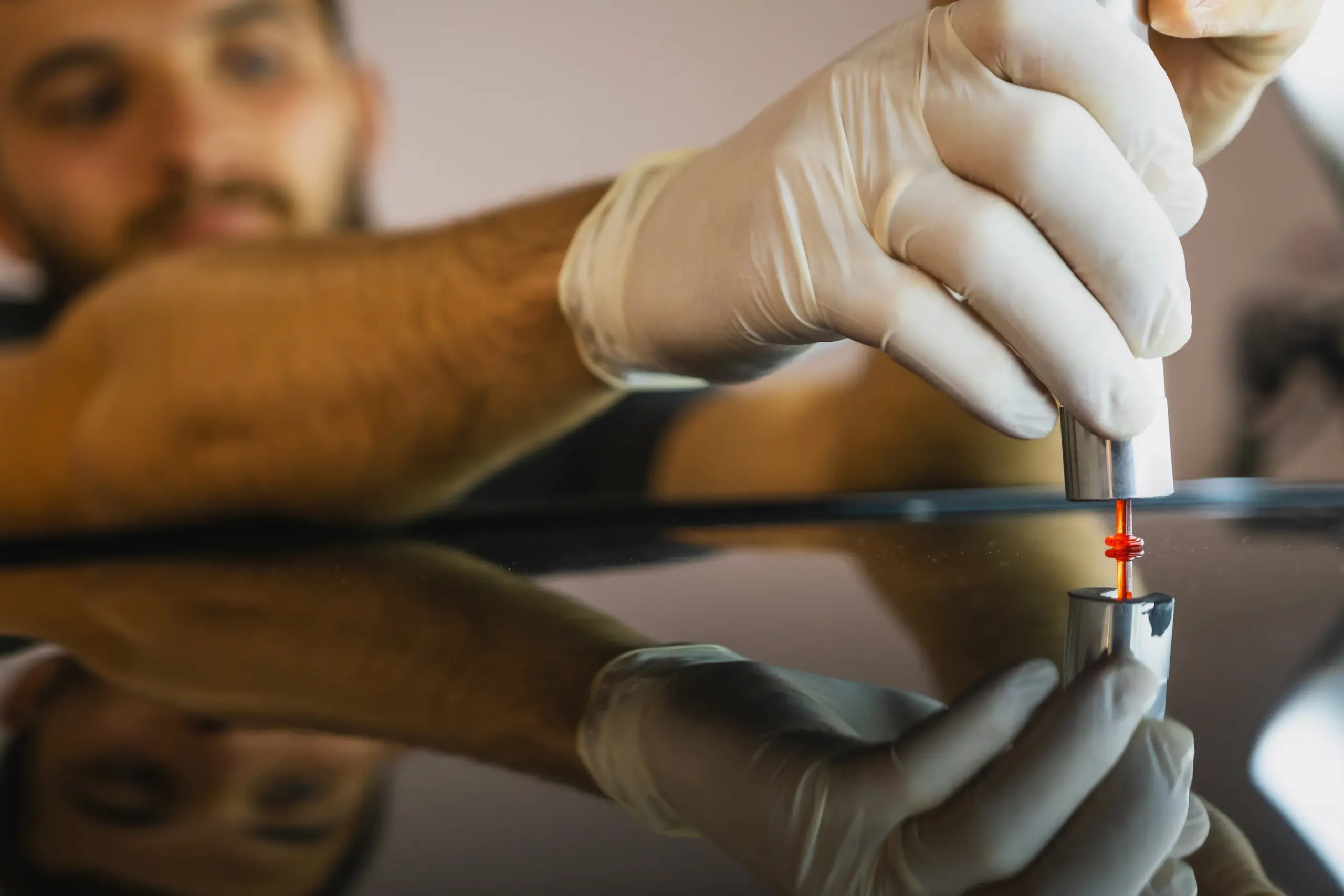 PDR technician using a precision tool to repair a dent on a vehicle panel